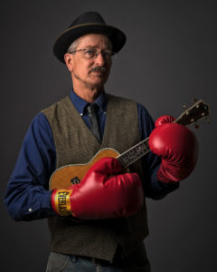 man with boxing gloves and ukulele