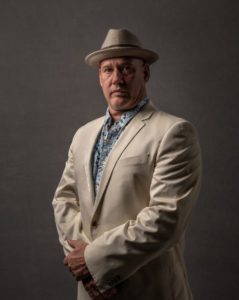 man in cream suit and straw hat