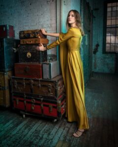 model in yellow dress with vintage luggage