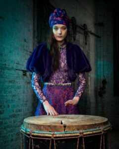 woman in purple playing large drum