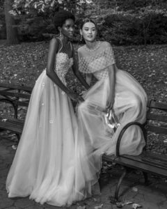 two models in bridal gowns in park