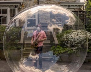 musician in a bubble outside his house
